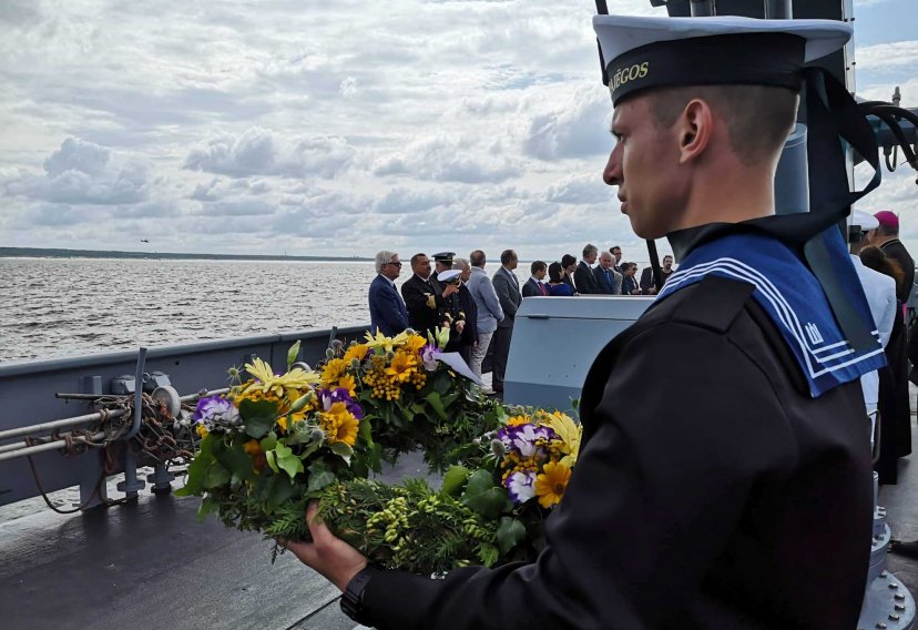 The Baltic Sea bursts into bloom: wreath tributes lowered onto the water from a ship and a...
